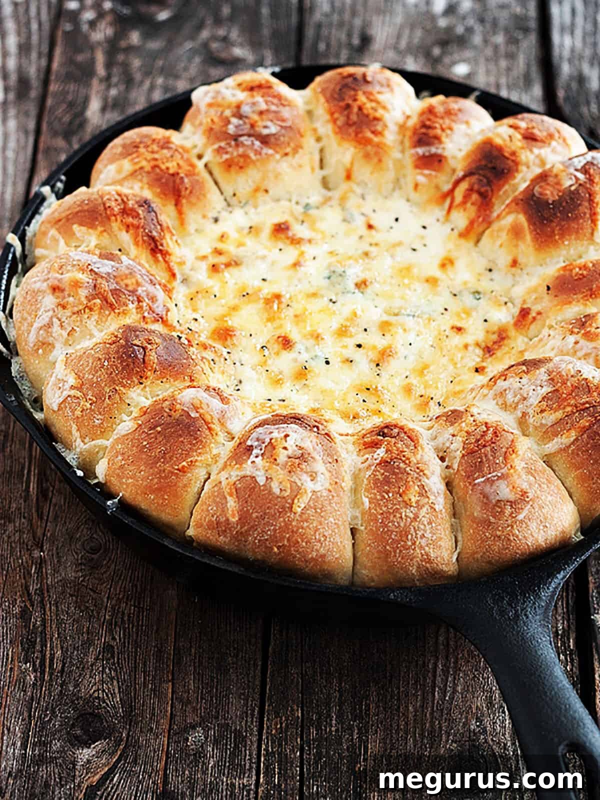 Close-up of Skillet Artichoke Spinach Dip with Bread Rolls