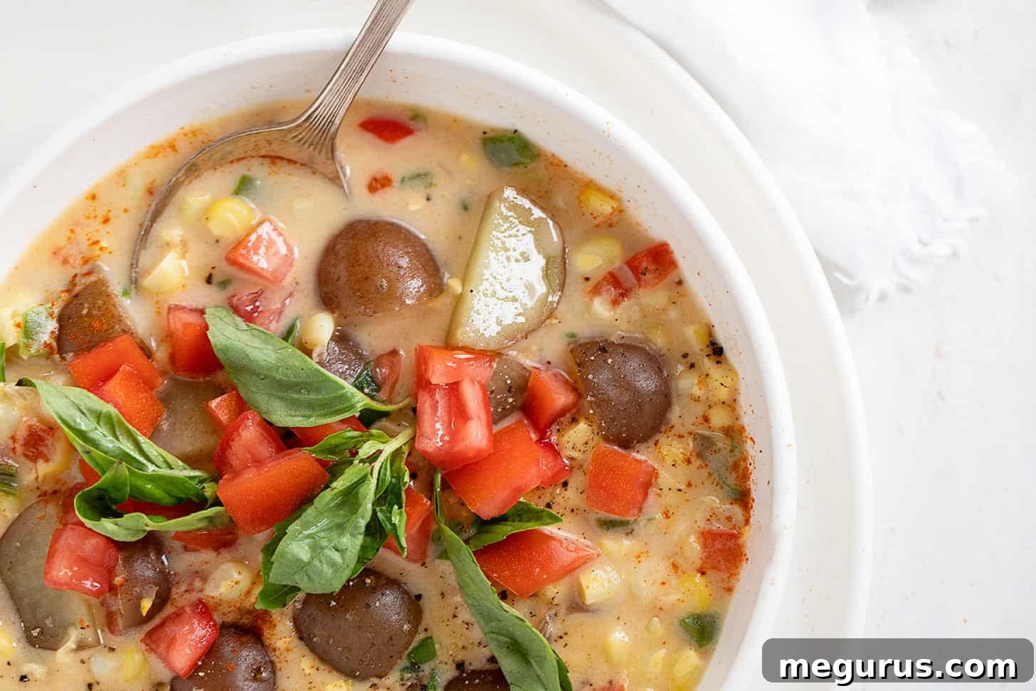 A bowl of light, creamy corn and potato chowder with fresh herbs, perfect for a summer or early fall meal.