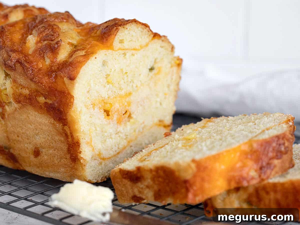 Sliced Jalapeño Corn Cheese Bread on a cooling rack, showcasing its textured crumb and cheese pockets.