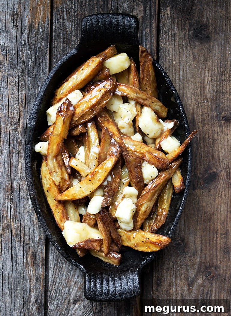 A close-up of finished authentic Canadian poutine, ready to be eaten with a fork