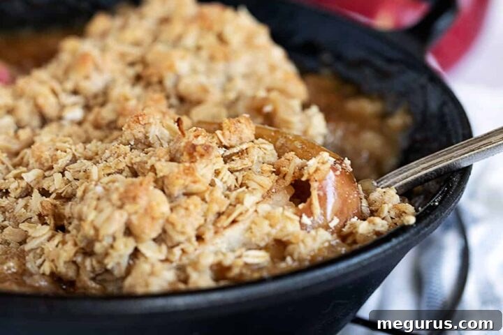baked apples topped with oat crumble in cast iron skillet