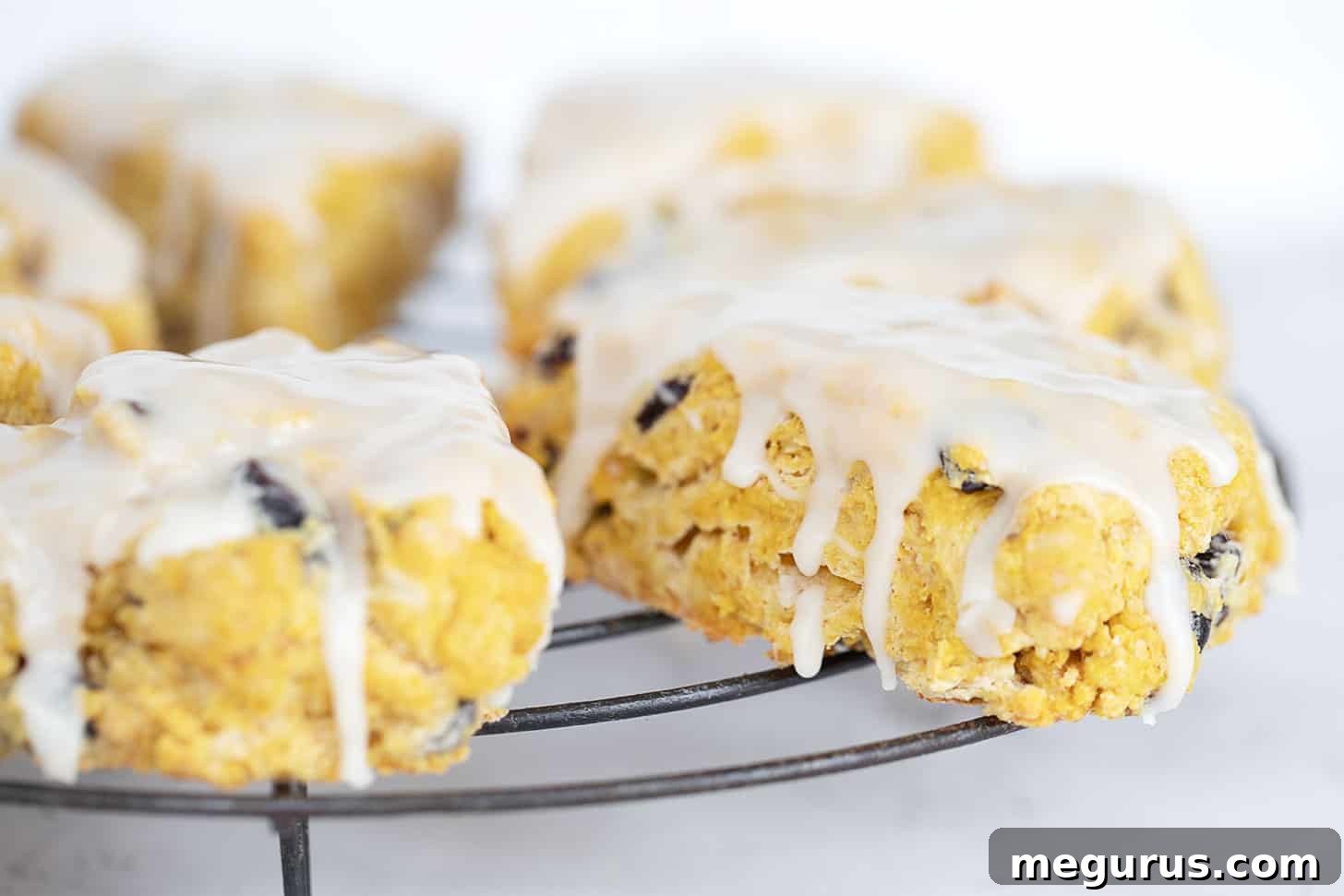 Golden brown maple glazed pumpkin scones on a cooling rack, ready to be enjoyed.