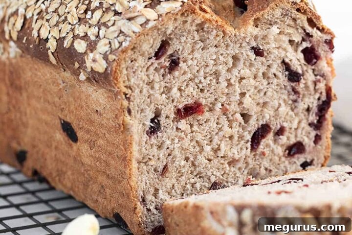 Sliced Cranberry Oatmeal Bread on a cooling rack, ready to be enjoyed.