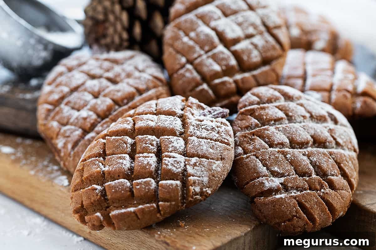 Festive gingerbread pinecone cookies arranged on a rustic wooden board, dusted with powdered sugar, ready for holiday celebrations.