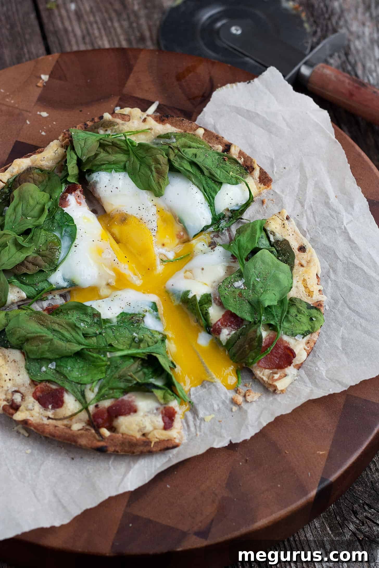Close-up of breakfast pita pizza showing the runny egg yolk and crispy crust.