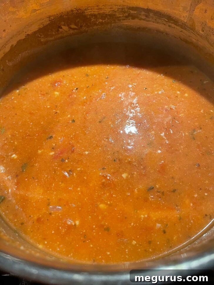 Finished tomato feta orzo soup in a pot, ready to serve.