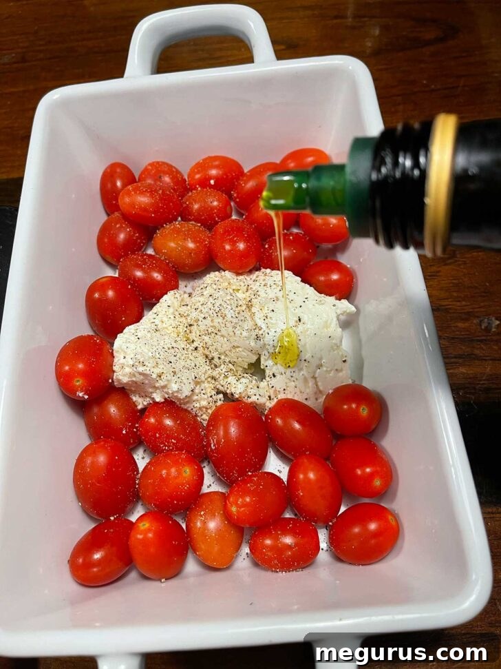 Cherry tomatoes and feta in casserole dish, ready for roasting.