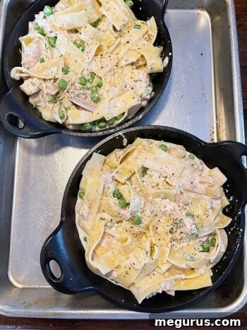 Tuna casserole spooned into small skillets for baking