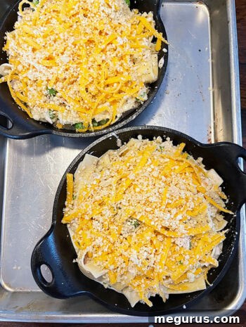 Tuna casserole in skillets with cheese and breadcrumb topping ready to bake