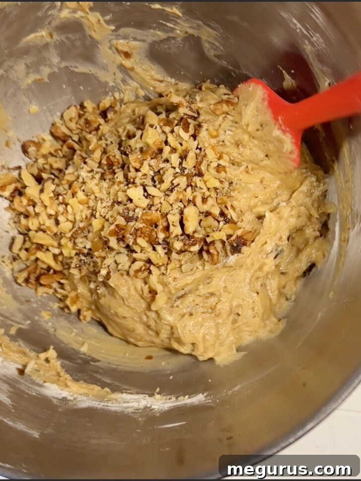 Chopped walnuts or pecans being folded into the date nut bread batter.