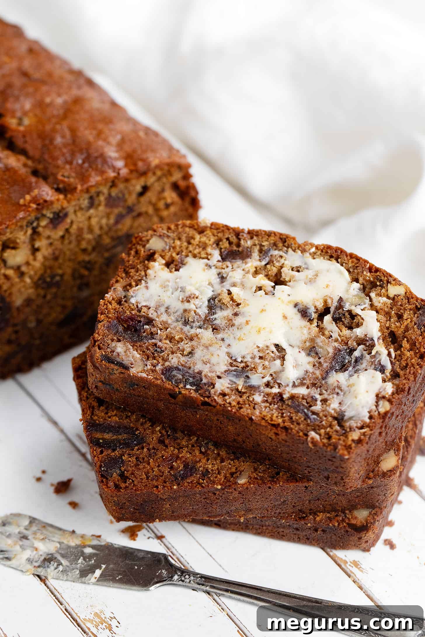 Close-up of buttery date nut bread slices, showcasing the texture and ready for serving.