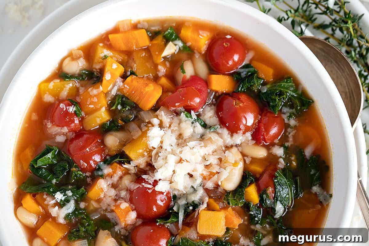 Hearty Fall vegetable soup in a white bowl, garnished with fresh herbs