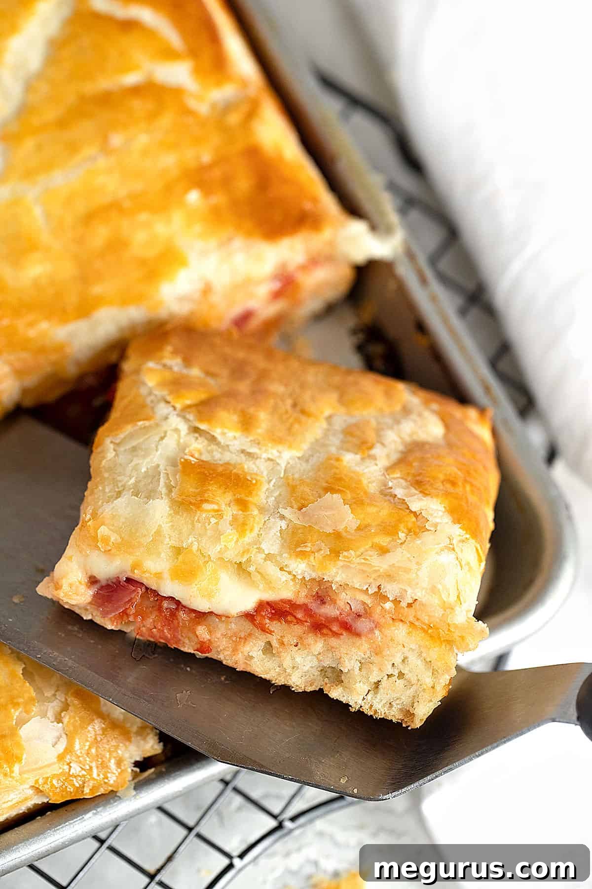 A whole Pizza Parigina in a pan with a single slice cut out, showcasing its layers.