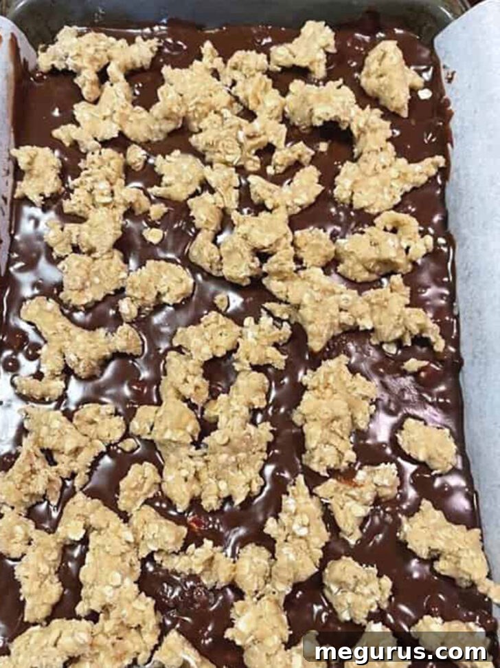 Small clumps of reserved dough scattered on top of the chocolate layer, ready for baking.