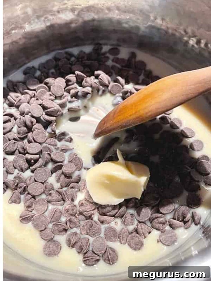 Sweetened condensed milk, chocolate chips, and butter melting together in a saucepan.
