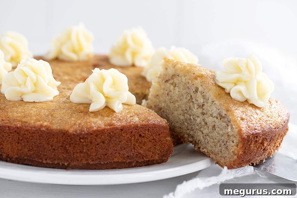 Delicious banana snack cake sliced with a dollop of cream cheese frosting on each piece