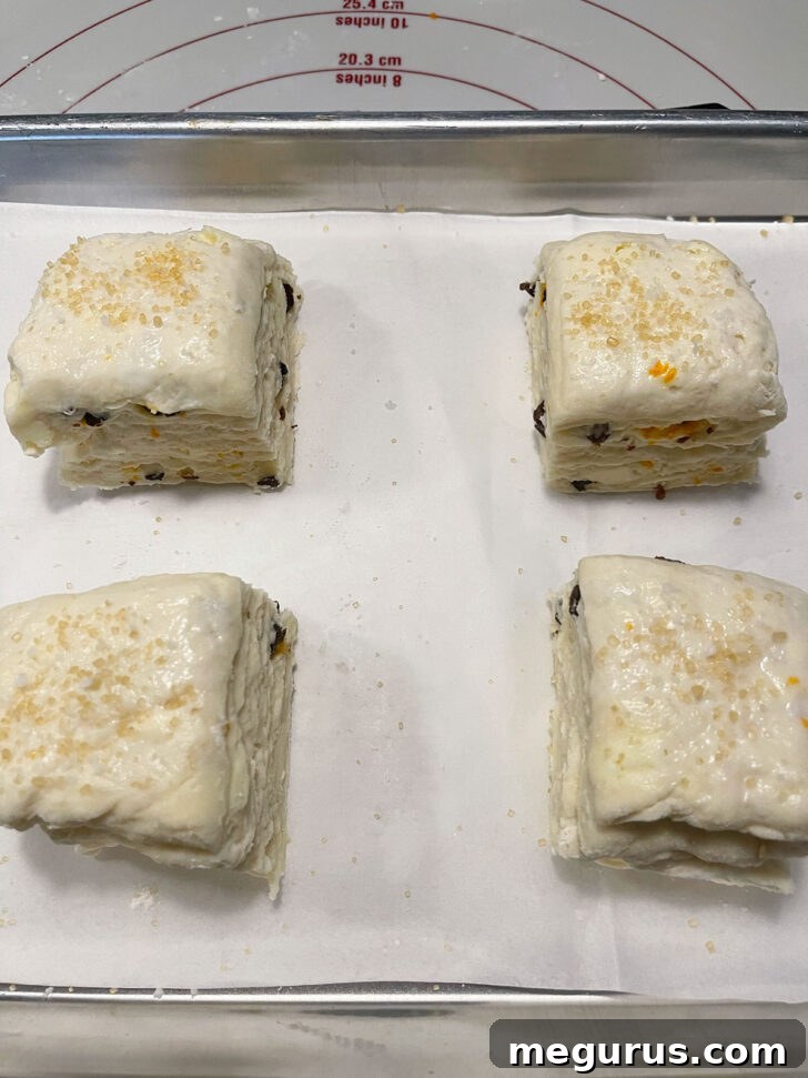Unbaked Irish scones arranged on a parchment-lined baking sheet, brushed with milk and sprinkled with sugar.