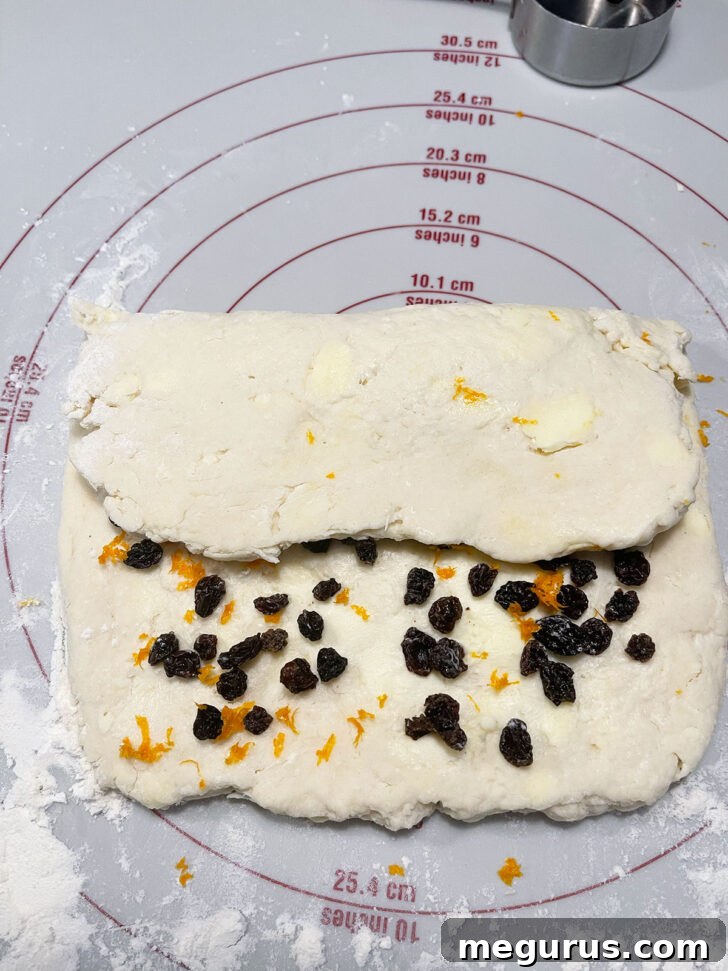 Folding the scone dough in a letter-fold technique to create layers.