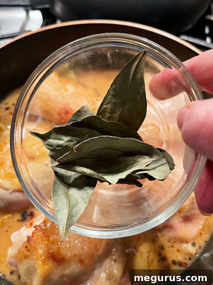 Adding bay leaves to the skillet.
