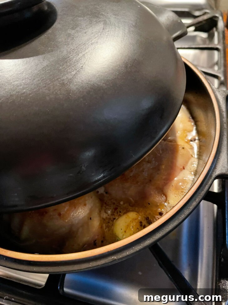 Partially covering the skillet with a lid.