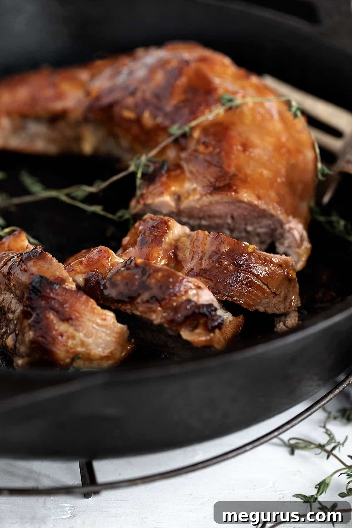 Perfectly cooked marinated pork tenderloin resting in a cast iron skillet