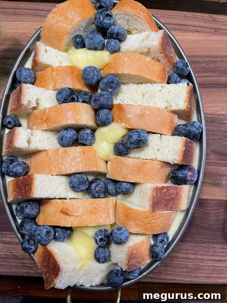 Blueberries and lemon curd scattered on top of pudding.