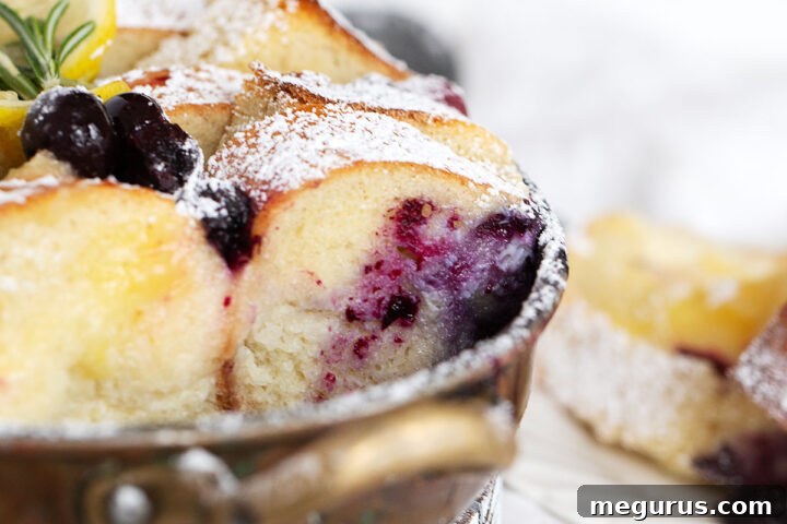 Blueberry lemon bread pudding in baking dish and spooned out onto a plate.