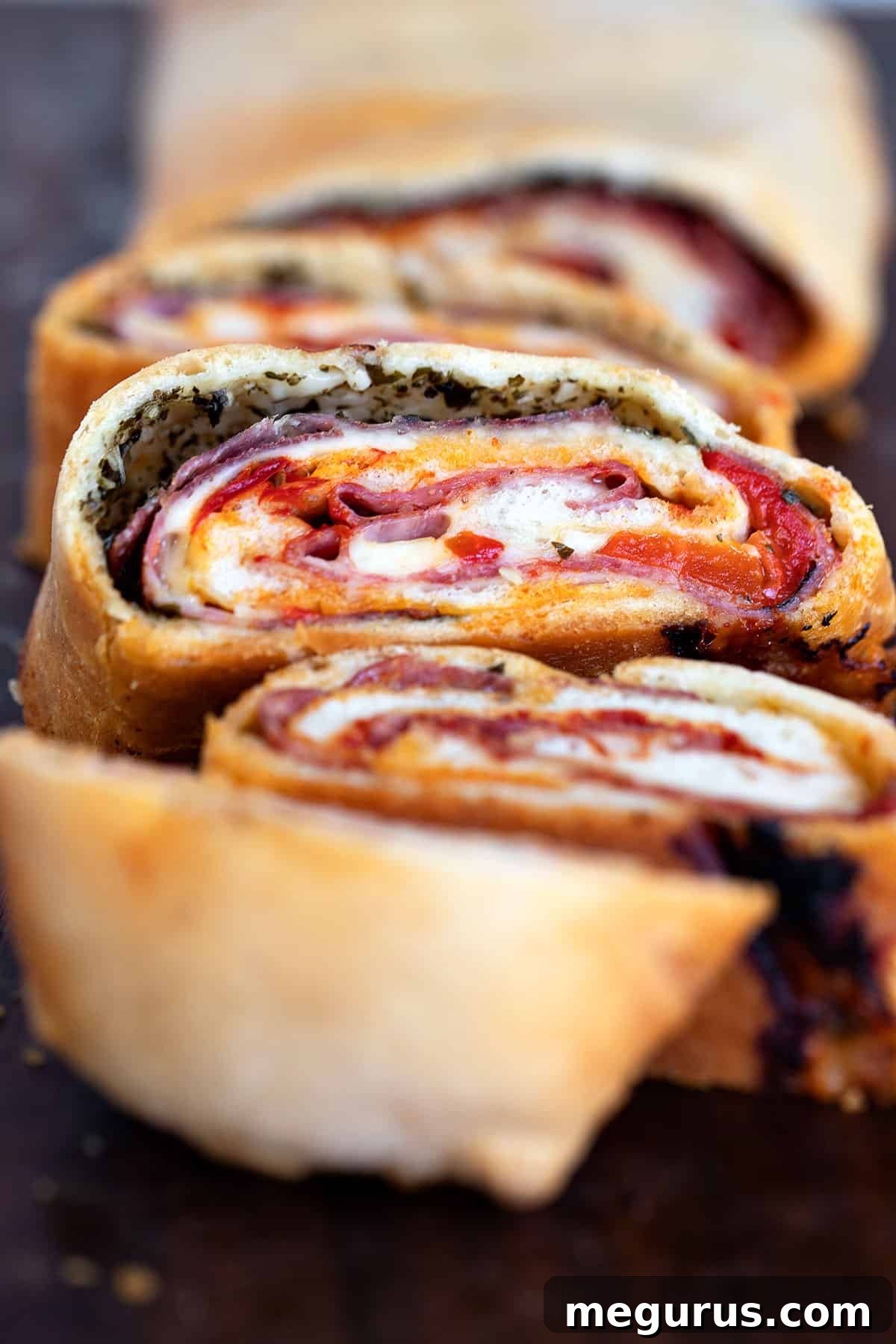 A beautifully baked stromboli, expertly sliced to reveal its delicious layers of meat and cheese, ready to serve.