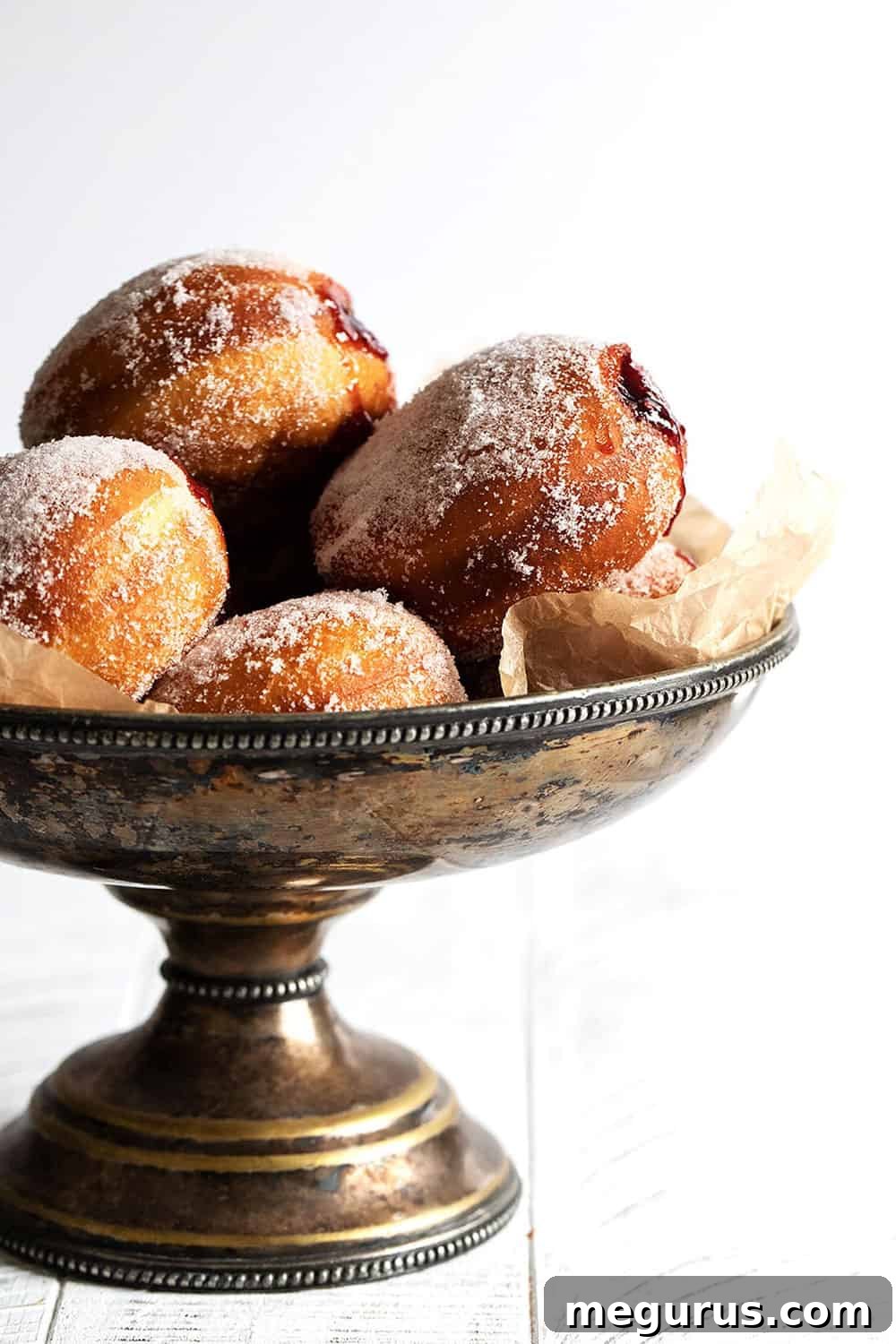 A close-up shot of an authentic Polish paczki with a delicate sugar coating on a silver platter.