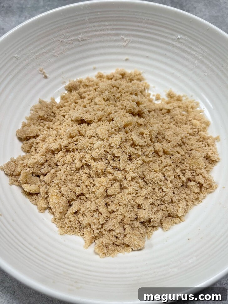Crumb topping ingredients mixed in a small bowl, showing a coarse, sandy texture.