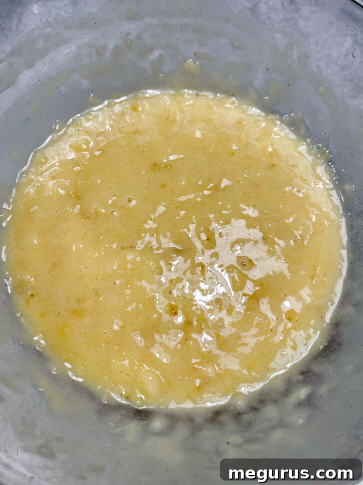 Wet ingredients for banana muffin batter thoroughly mixed in a large bowl.