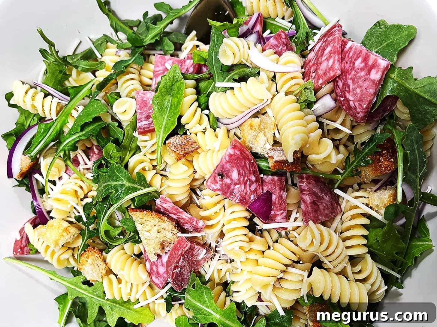 Pasta salad with salami in a bowl.