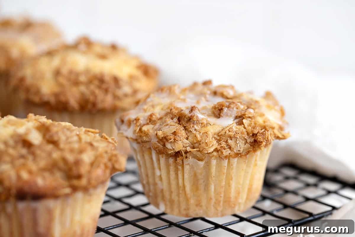Freshly baked peach crisp muffins cooling on a wire rack, showcasing their golden crumble topping and tender interior.