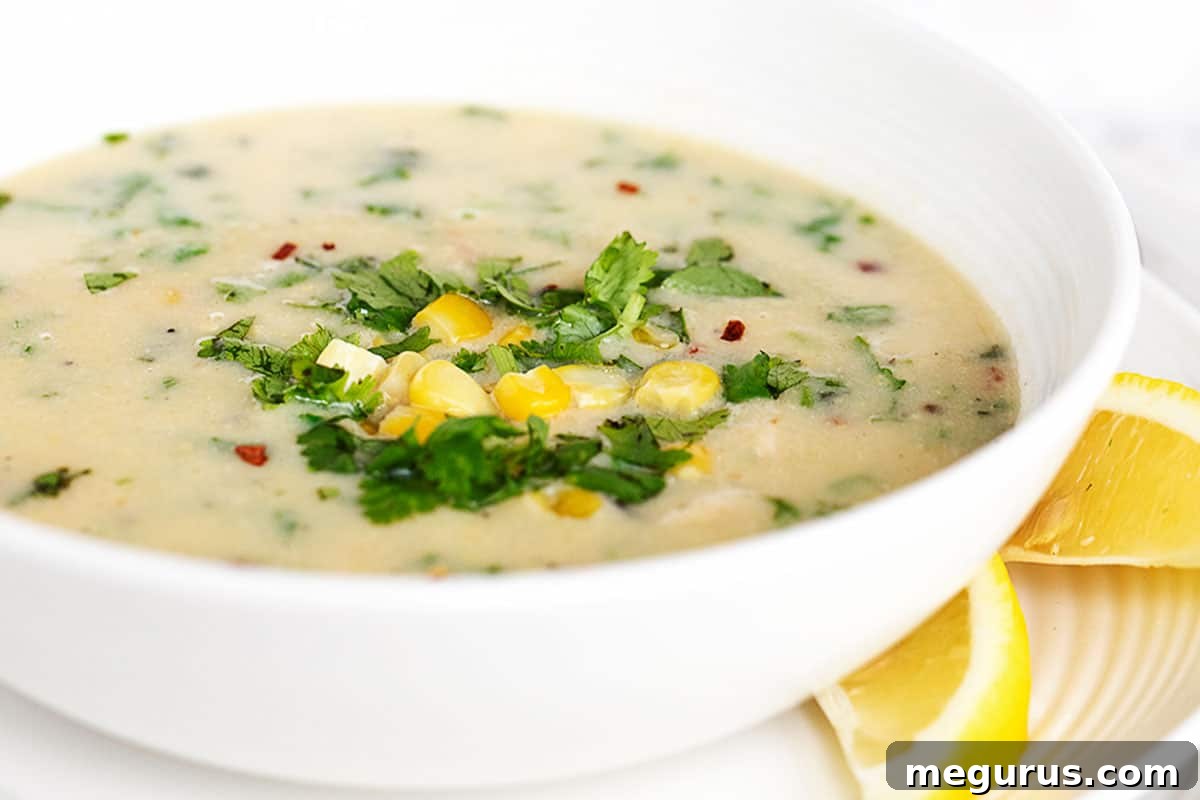 creamy chicken corn chowder with coconut milk in a white bowl, garnished with fresh cilantro
