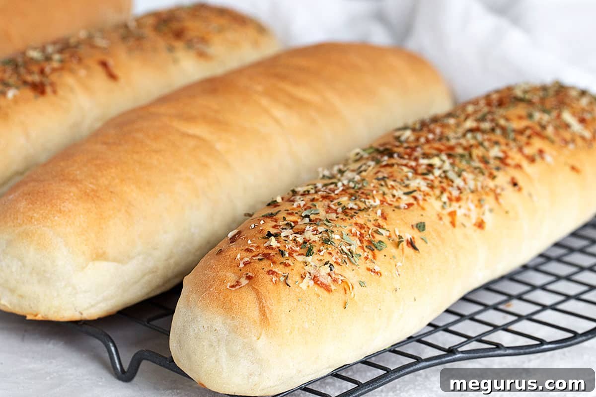 Freshly baked sub buns cooling on a wire rack, golden brown and inviting.