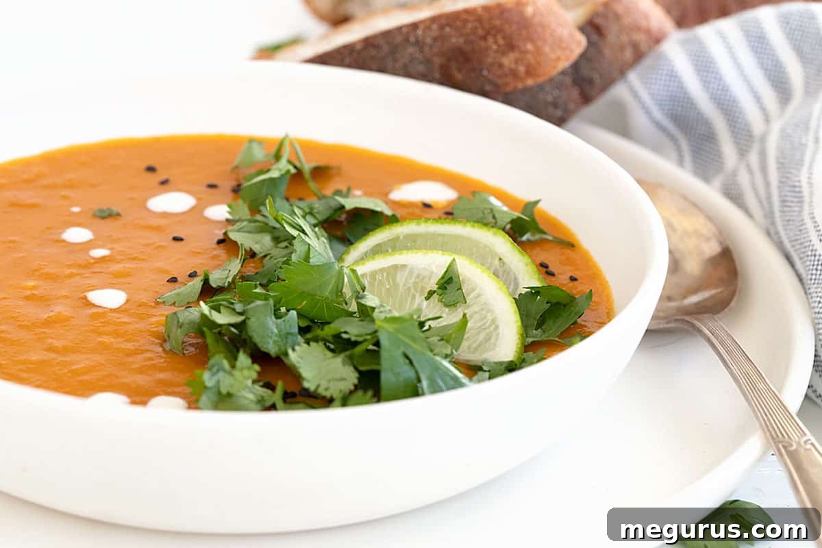 Thai sweet potato soup in bowl with limes and cilantro