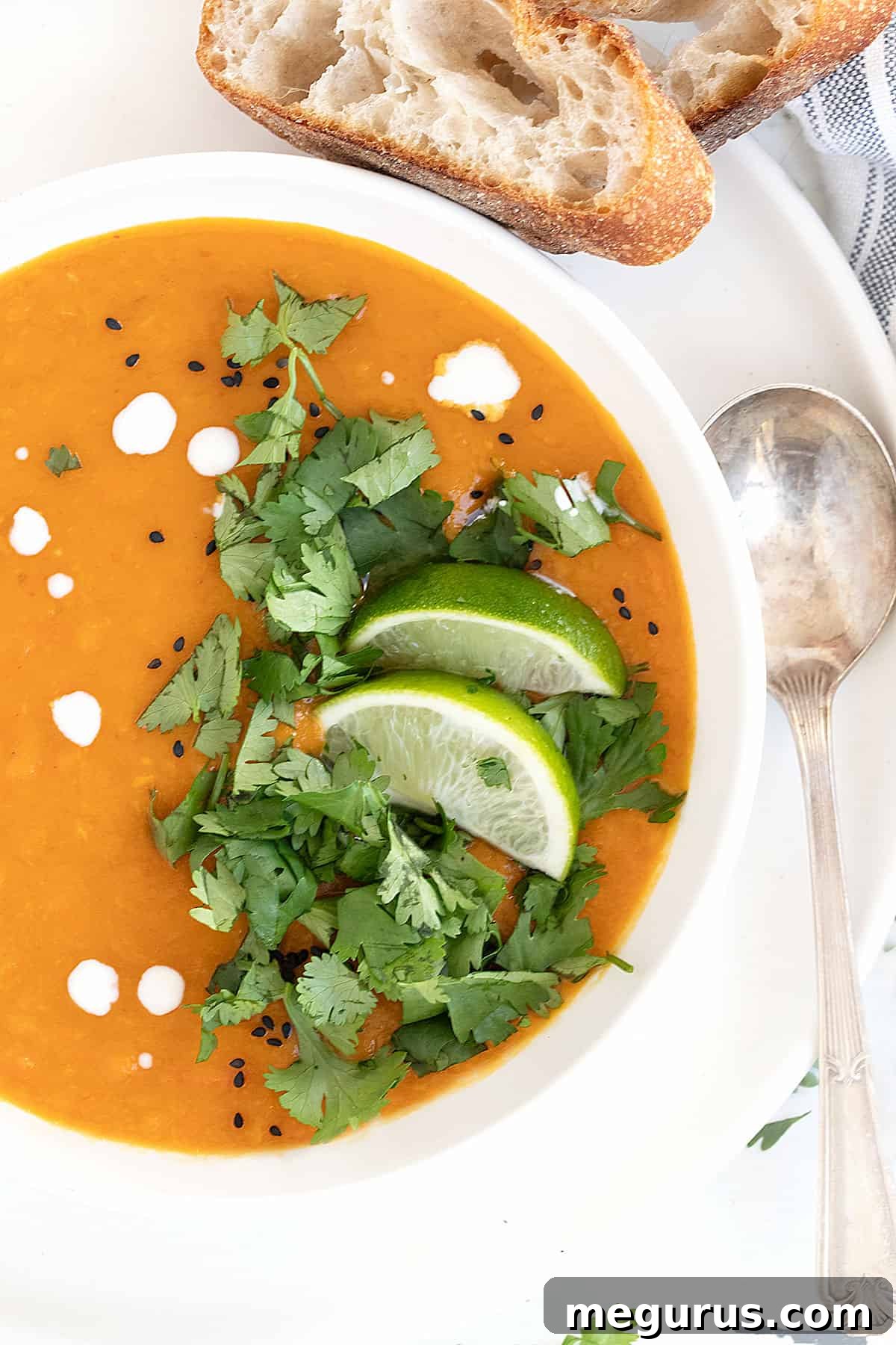 Thai sweet potato soup in bowl with limes and cilantro