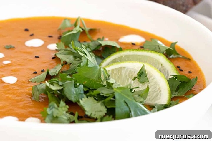 Thai sweet potato soup in bowl with limes and cilantro