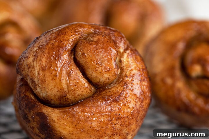 A plate of freshly baked sticky cinnamon knots with a rich glaze