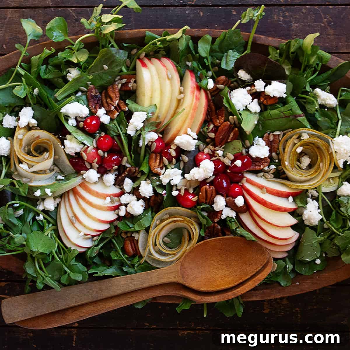 Fall harvest salad in wooden bowl with wooden spoons