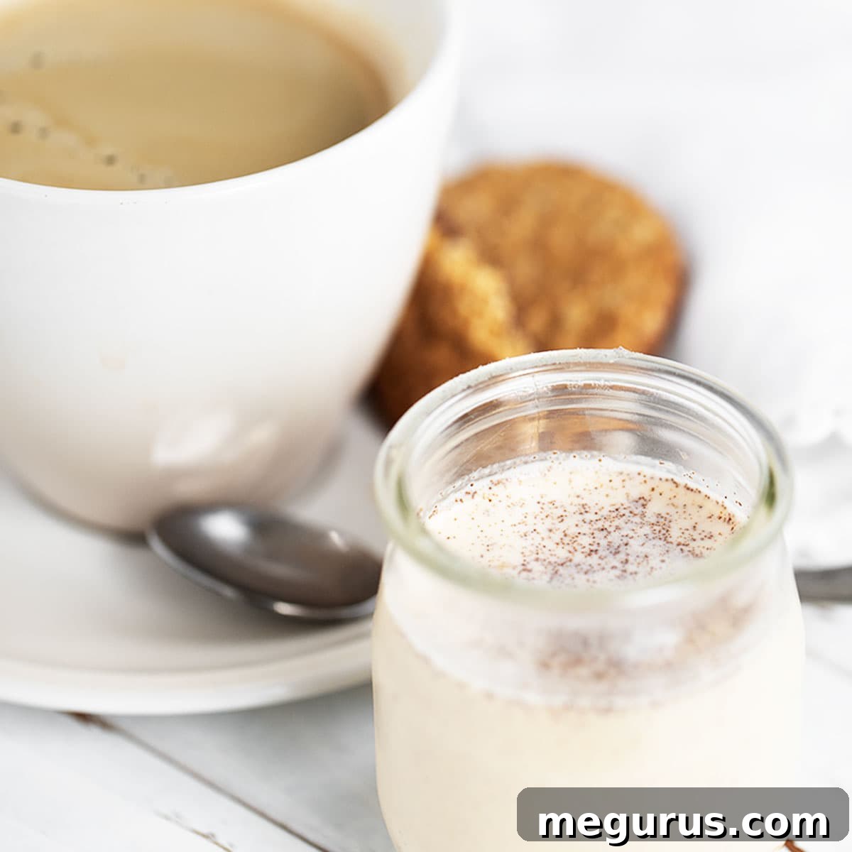 pumpkin spice coffee creamer with cup of coffee behind