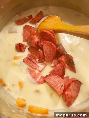The browned kielbasa being added back into the soup pot.