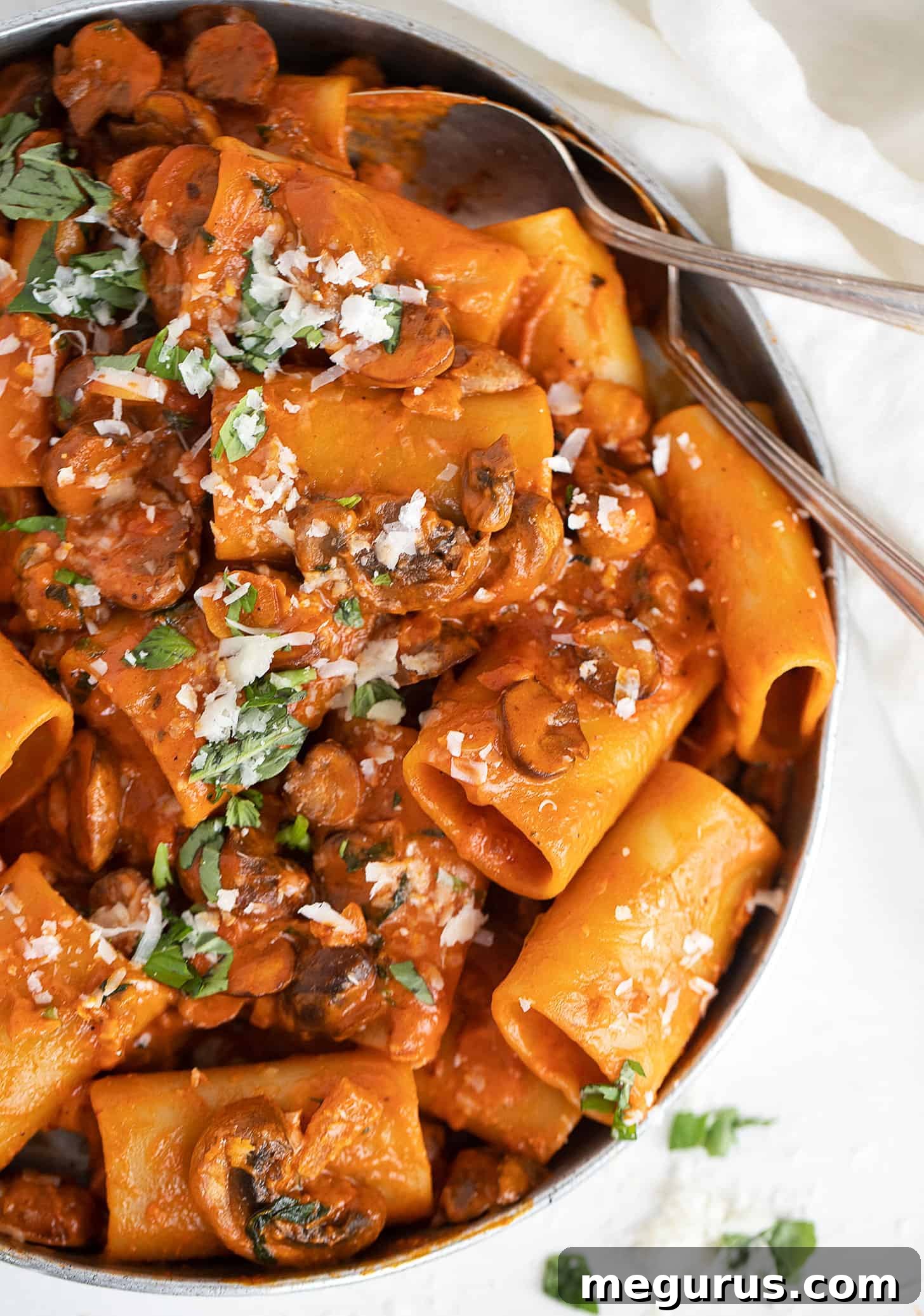 Generous serving of Mushroom Ragù Pasta in a decorative platter, garnished with fresh basil