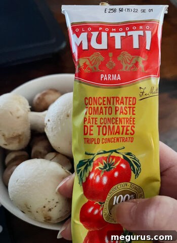Close-up of fresh mushrooms and a tube of concentrated tomato paste, ready for cooking