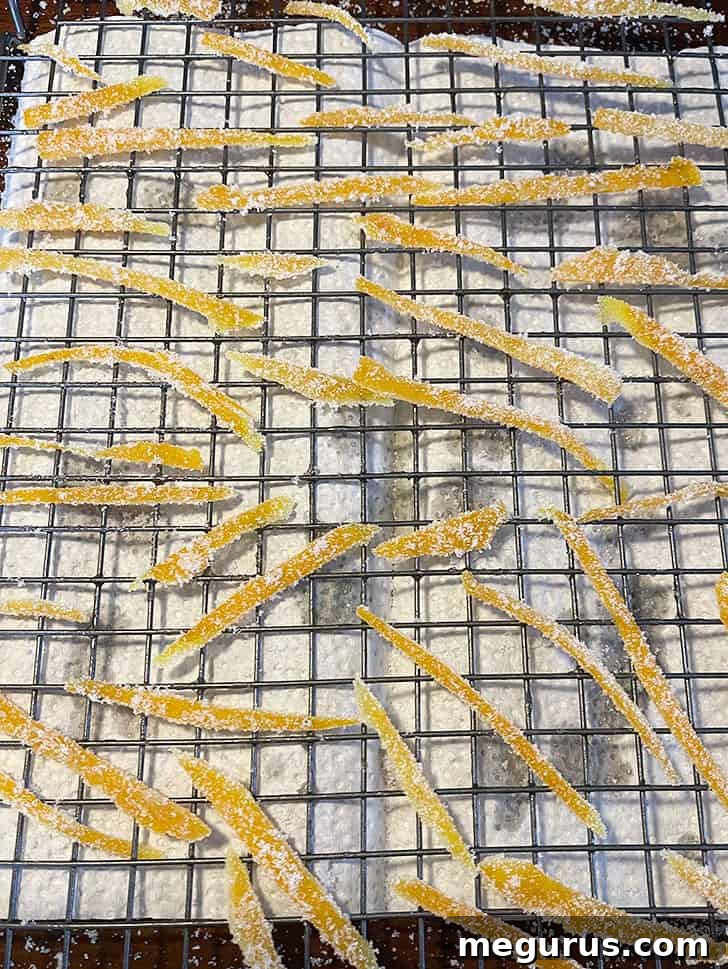 Sugar-coated candied orange peel drying thoroughly on a wire cooling rack.