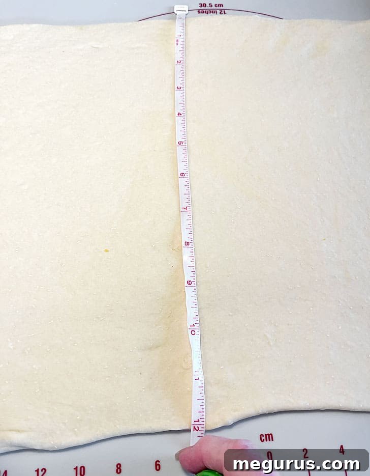Dough being measured after rolling out to ensure correct dimensions for layering.