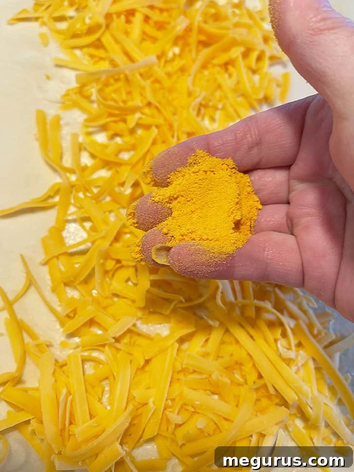 The right side of the dough being folded over the first cheese and butter layer.
