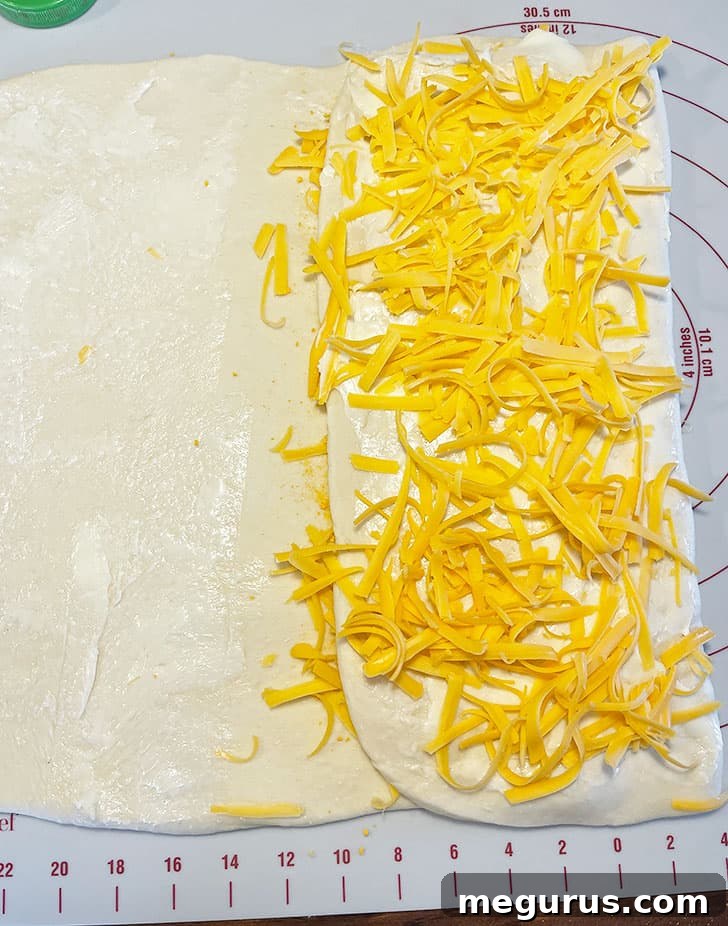 The left side of the dough being folded over the layered cheese and butter.