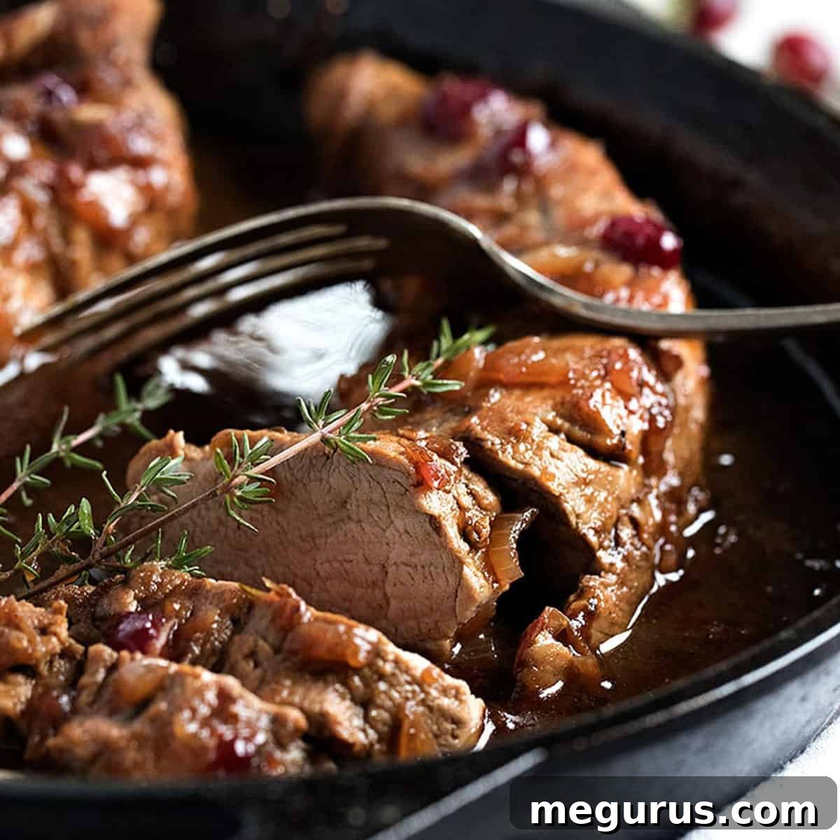 Cranberry balsamic pork tenderloin sliced in cast iron skillet