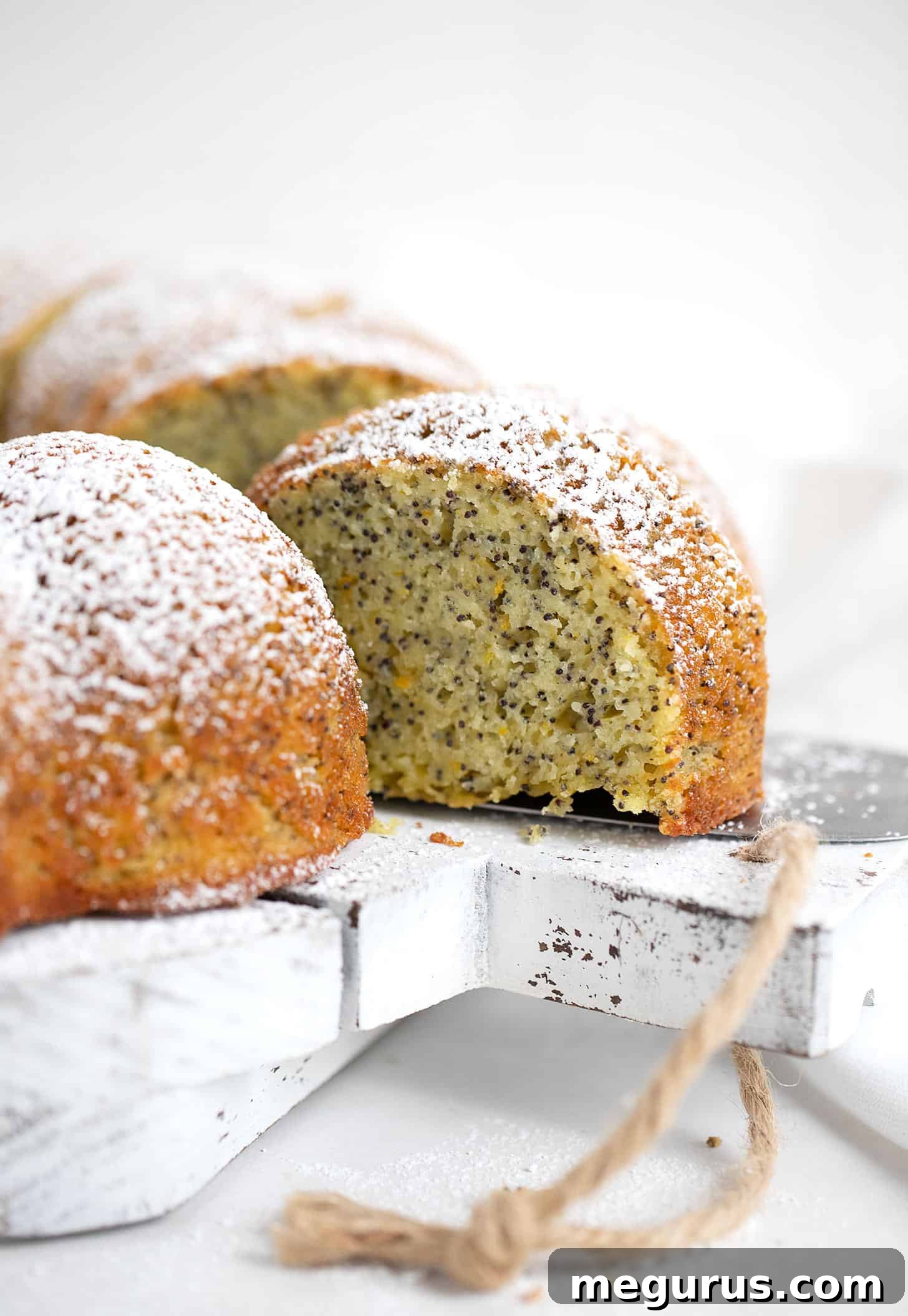 A perfectly baked Orange Poppy Seed Bundt Cake, dusted with powdered sugar, ready for serving.